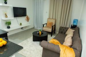 a living room with a couch and a tv at Kari Cozy Homes in Nairobi