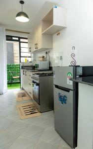 a kitchen with a stove and a refrigerator at Kari Cozy Homes in Nairobi