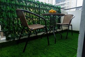 two chairs and a table on a balcony with grass at Kari Cozy Homes in Nairobi