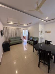 a living room with a table and a couch at Sathya HS-2 Bedroom Family Apartments with Balcony in Guruvāyūr