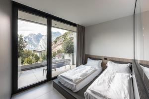 two beds in a room with a large window at Gardea SoulFamily Resort in Nago-Torbole +98 photos