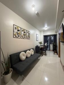 a living room with a black couch and a table at Obetskie's Haven Condotel in Manila