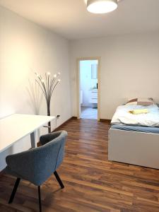 a bedroom with a bed and a desk and a table at Große möblierte Wohnung im Zentrum von Lage in Lage