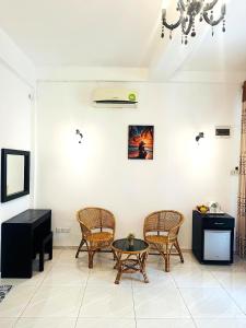 a living room with chairs and a table and a chandelier at L&D Stay Inn in Hikkaduwa