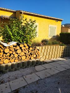 a pile of logs in front of a house at CHARMING studio proche centre in Castellane +2 photos