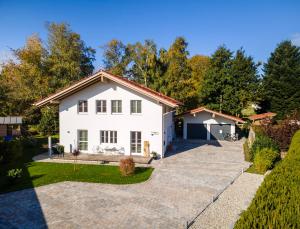 a white house with a driveway at Ferienwohnung Buchwald mit schöner Holzterrasse in Übersee