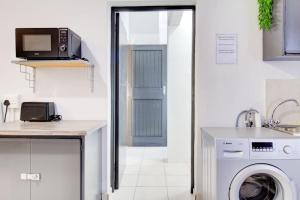 a kitchen with a washing machine and a microwave at Spacious Valkyrie One-bedroom in Centurion