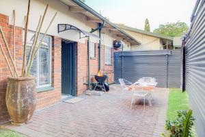 a patio with a table and chairs and a fence at Spacious Valkyrie One-bedroom in Centurion