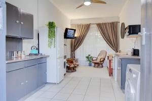 a kitchen with blue cabinets and a white tile floor at Spacious Valkyrie One-bedroom in Centurion