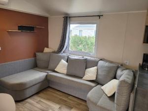 トレイユにあるGrand mobil-home familial accès direct à la mer 5 étoileのソファと窓のあるリビングルーム