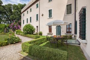 een tafel met een paraplu voor een gebouw bij Apartment CastellONE with Pool in Lazise