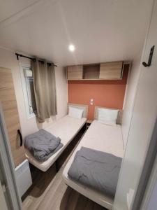 トレイユにあるGrand mobil-home familial accès direct à la mer 5 étoileのトレーラー内の小さな部屋のベッド2台