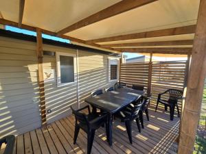 トレイユにあるGrand mobil-home familial accès direct à la mer 5 étoileの木製デッキ(テーブル、椅子付)