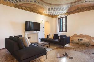 een woonkamer met een bank en een tv bij Apartment CastellONE with Pool in Lazise