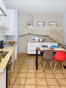a kitchen with a table and some chairs in it at Le Gaveau superbe T3 médiéval Internet WiFi gratuit Arènes historiques in Béziers