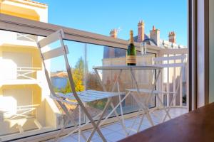 a couple of chairs and a bottle of wine on a balcony at Appartement cœur de ville avec balcon - 3 personnes in Les Sables-dʼOlonne