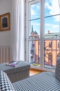 a room with a window with a view of a building at Horyzont Apartamenty- Apartament Ratuszowy- stylowy apartament w samym sercu starówki in Kołobrzeg
