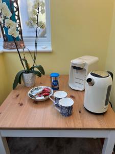 Una mesa de madera con cafeteras y tazas encima. en Hikers Rest, en Findon