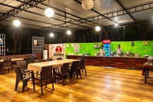een restaurant met een tafel, stoelen en een toonbank bij Dandeli Heritage Resort in Dandeli