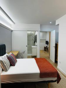 Un dormitorio con una cama grande y un baño. en Alameda Lofts Pontevedra, en Pontevedra 26 fotos más