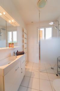 a white bathroom with a shower and a sink at Villa individuelle Nernier proche lac in Nernier
