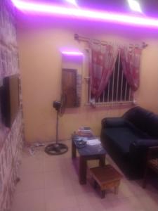 a living room with a couch and a purple light at Ensuite in Ejigbo