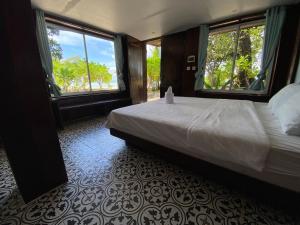 sypialnia z łóżkiem i dwoma dużymi oknami w obiekcie Kerfuffle Bay w mieście Kaôh Rŭng (1)