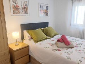 Un dormitorio con una cama y una lámpara en una mesita de noche. en Hervas Centro Apartamento IDEAL FAMILIAS 6 adultos y 2 niños-, en Hervás 28 fotos más