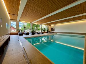 an indoor swimming pool with chairs and a swimming pool at Studio Top im des Alpes in Flims