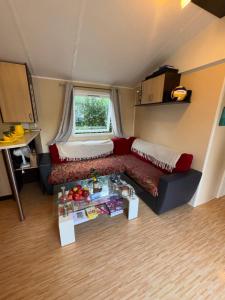 a living room with a couch and a table at Mobilhome Évasion Fun Activités, détente et nature aux Fontaines in Ivry-la-Bataille
