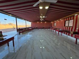 a large room with benches and tables and windows at Talira Luxury Camp in Wadi Rum