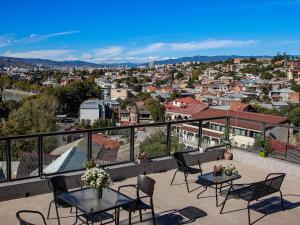 a balcony with tables and chairs overlooking a city at Hotel Marioni in Tbilisi City