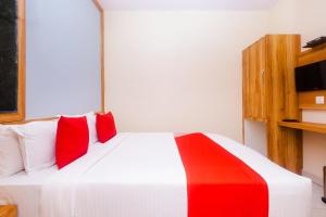 a bedroom with a bed with red and white pillows at Hotel Amber Sun City in Mumbai