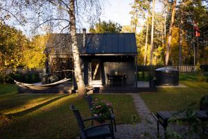 una casa con una hamaca en un patio en Baltrozes, en Ādaži
