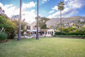 a house with a hammock in a yard with palm trees at Can Gat in Pollença