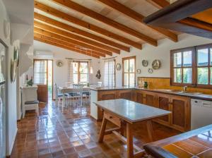 a large kitchen with wooden floors and wooden ceilings at Can Gat in Pollença