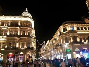 a group of people walking down a city street at night at Khatai Hotel & Restaurant in Baku