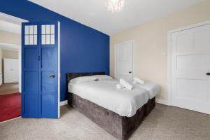 a bedroom with a bed with a blue wall at Convenient 2BR House with Free Street Parking in Middleton
