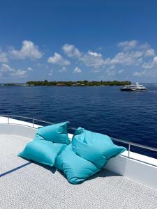 ein Boot mit zwei blauen Kissen am Wasserrand in der Unterkunft Ritrella Floating Hotel in Male City