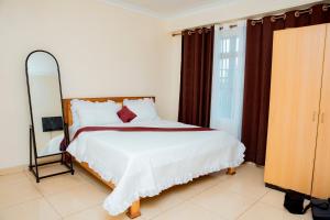 a bedroom with a bed with a large mirror at THELIGHT SUITES KIGALI Rwanda in Kigali
