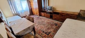 a room with a table and chairs and a television at Apartament Bozias Muncitori in Tîrnăveni