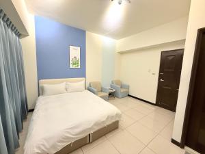 台中市にある台中住宿の白いベッドと青い壁のある寝室