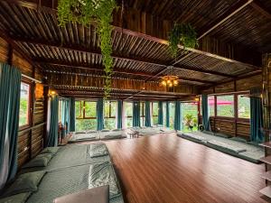 a large room with a wooden floor and windows at Michi Camp Lạng Sơn in Hữu Lũng