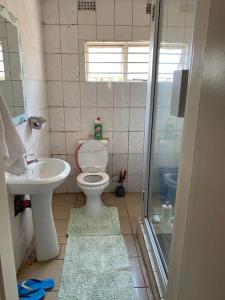 a bathroom with a toilet and a sink and a shower at Peaceful Sleep B&B in Kitwe