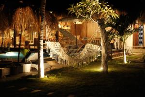 un hamac suspendu entre deux palmiers dans une cour dans l'établissement Alinn Villas, à Nusa Lembongan