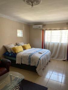 a bedroom with a bed with yellow pillows and a window at Peaceful Sleep B&B in Kitwe