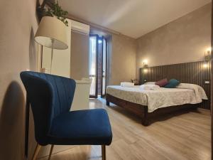 a bedroom with a bed and a blue chair at Albergo B&B Tenesi in Manerba del Garda +102 photos