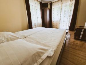 a bedroom with two white beds and a window at Casa Sonne Bușteni in Buşteni