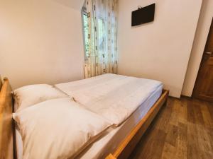 a small bed in a room with a window at Casa Sonne Bușteni in Buşteni