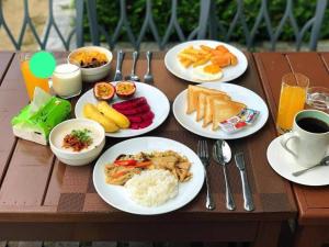 - une table avec des assiettes de petit-déjeuner dans l'établissement VangVieng Charming Boutique Hotel, à Vang Vieng